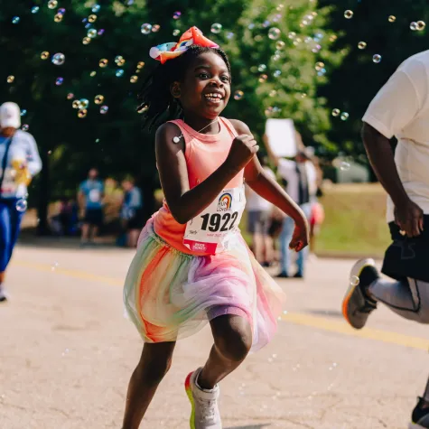 Young girl running with bubbles