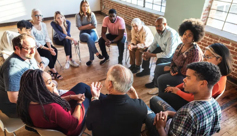 Group of people sitting in a circle talking 