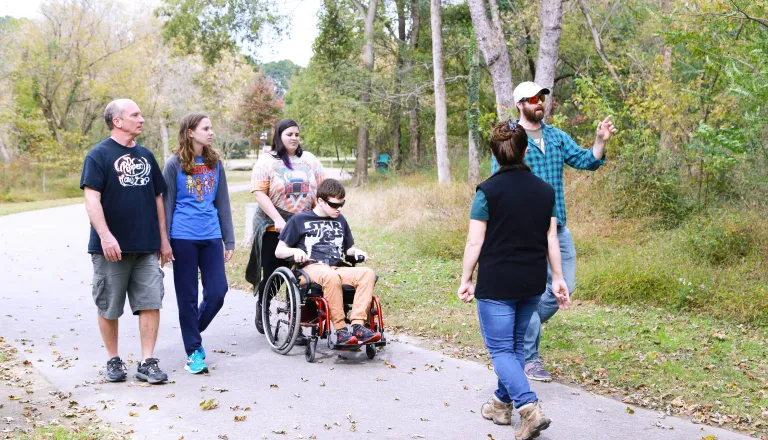 group of adults walking and one in a wheelchair