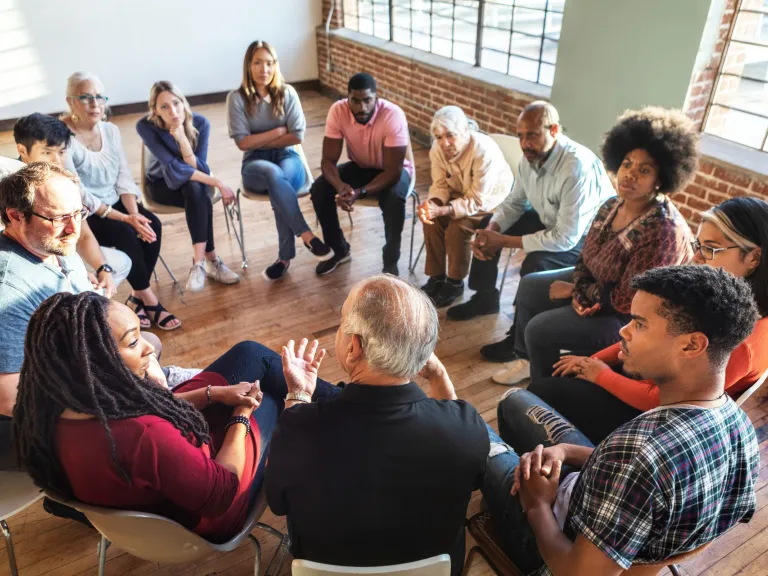 Group of people sitting in a circle talking 