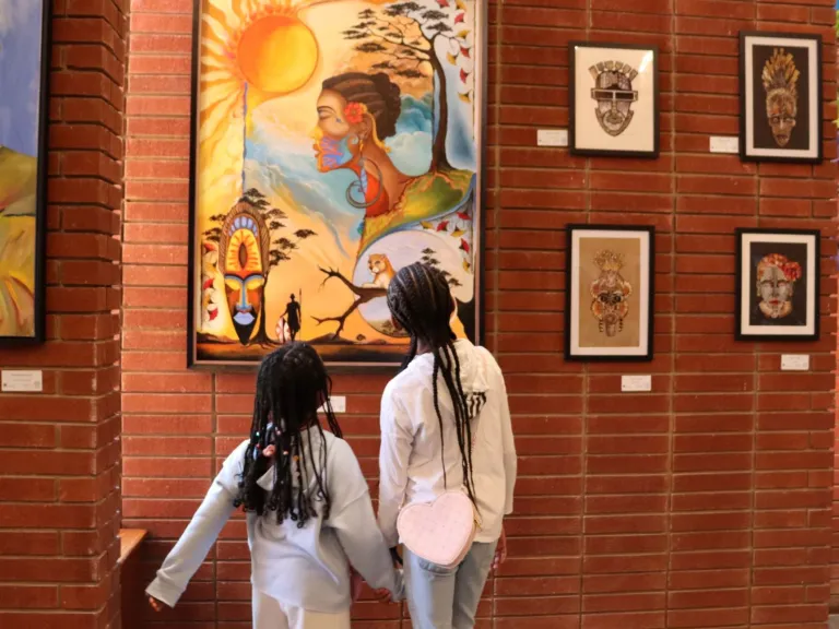 Two girls viewing art in the 2025 Living In Color Exhibit